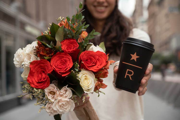 Person holding Starbucks Reserve coffee and pumpkin spice bouquet